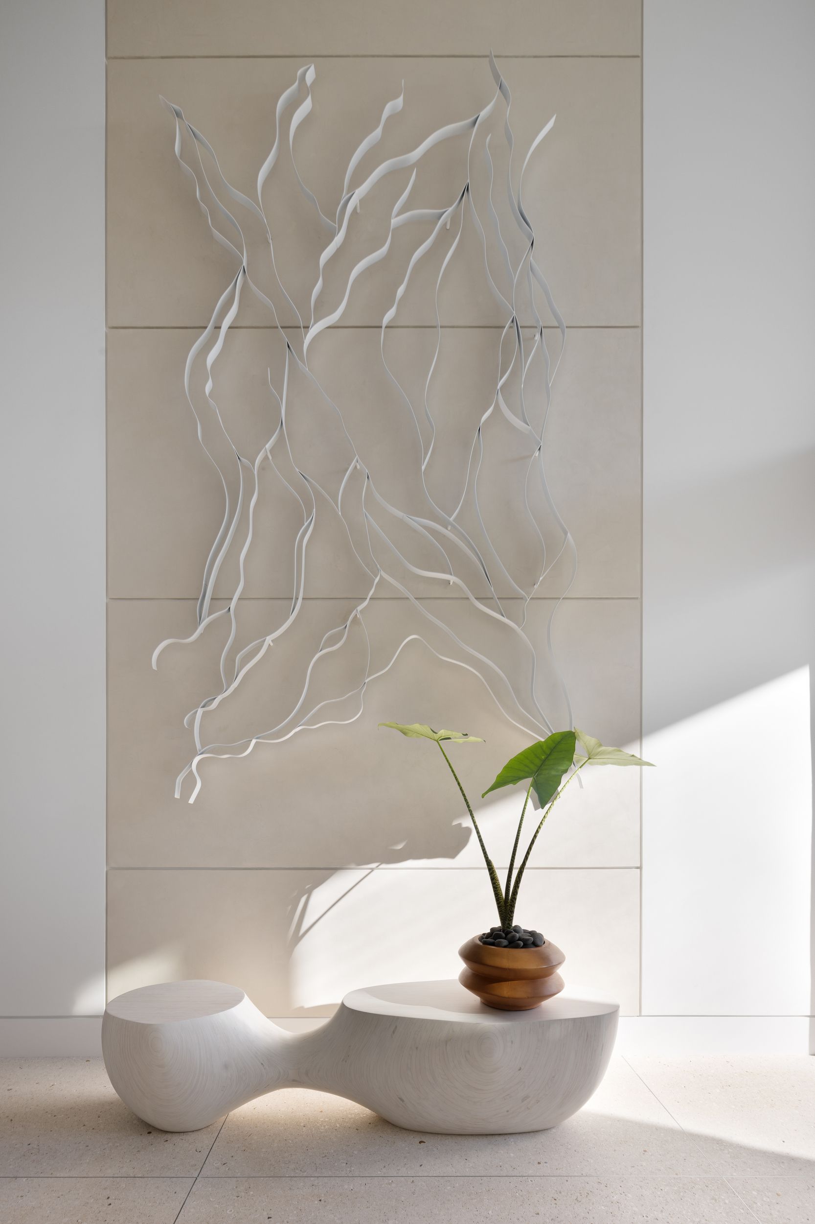 Abstract wall art with a bench and plant. Light-colored wall with white lines. White, organic-shaped bench. Plant with green leaves.