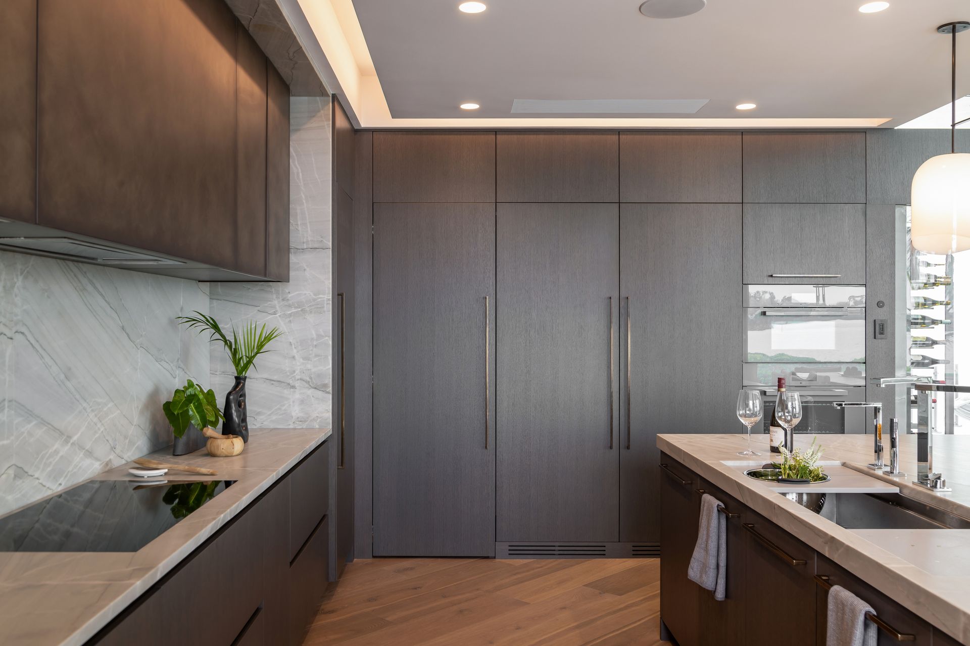 Modern kitchen with dark wood cabinets, light countertops, and an island.