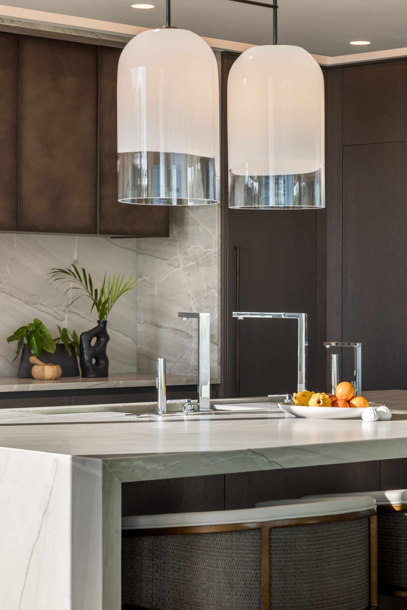 Modern kitchen with pendant lights, a stainless steel faucet, and a light-colored countertop.