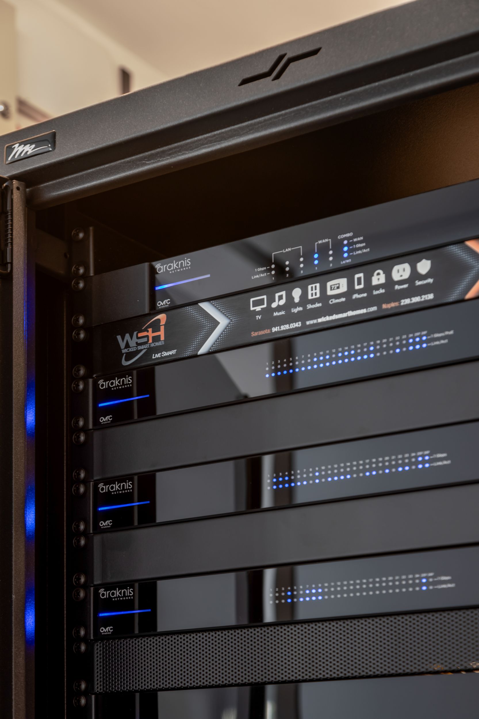 Black server rack filled with electronic devices, glowing blue lights.