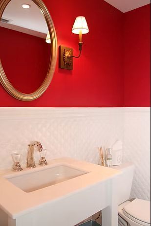 Red and white bathroom with a sink, mirror, and light fixture.