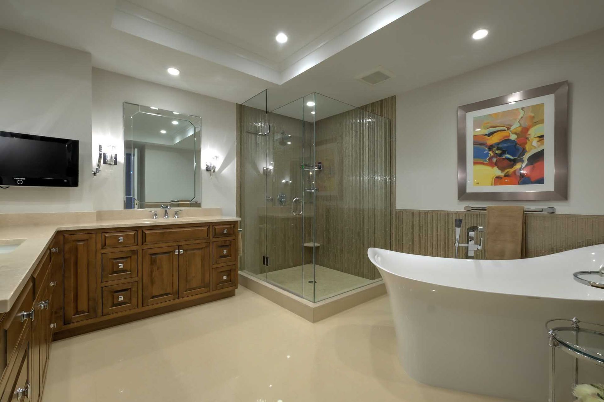 Luxury bathroom with a vanity, shower, and freestanding tub. Cream and brown tones.