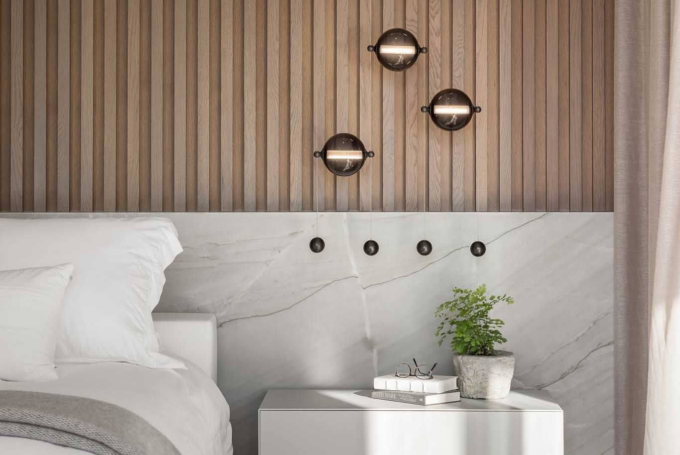 Bedroom with wooden accent wall, marble headboard, and bedside table with plant and books.