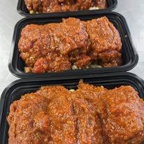 Three plastic containers filled with meat and sauce are sitting on a table.