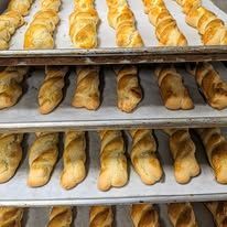 A bunch of rolls are sitting on a tray in a bakery.
