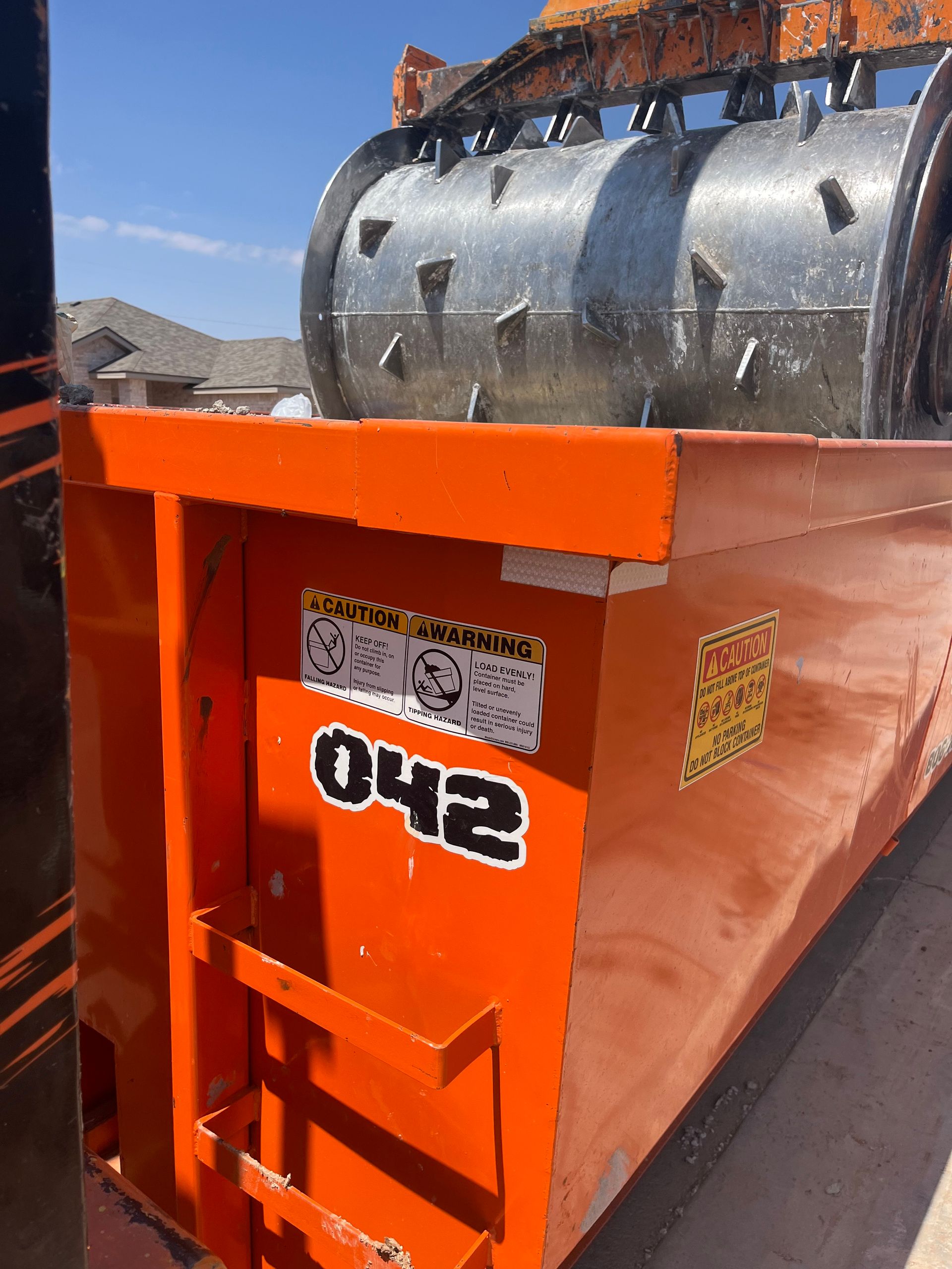 An orange roll-off dumpster marked 
