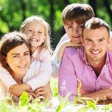 A family is posing for a picture in the grass.