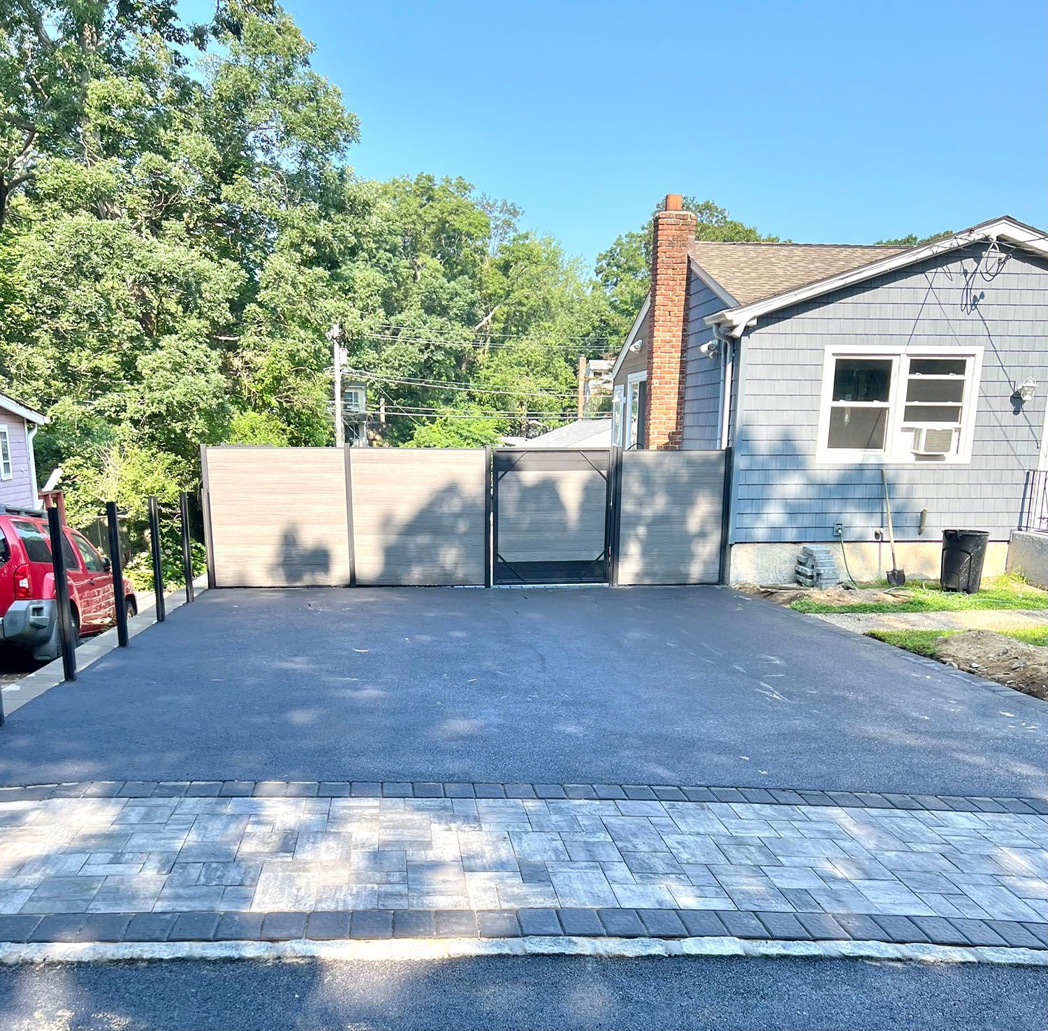 A car is parked in a driveway in front of a house.