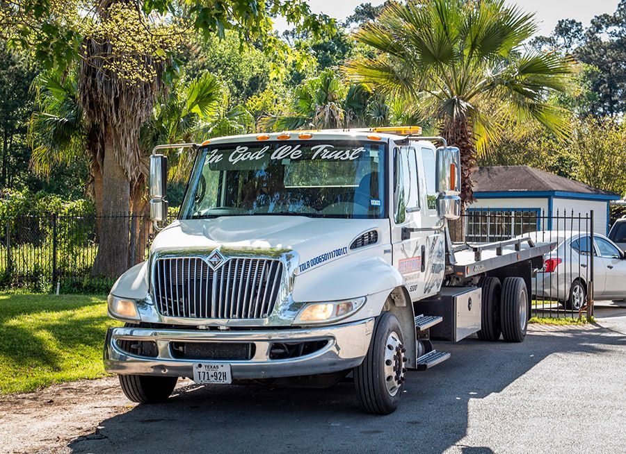 A white tow truck is parked in front of a house.
