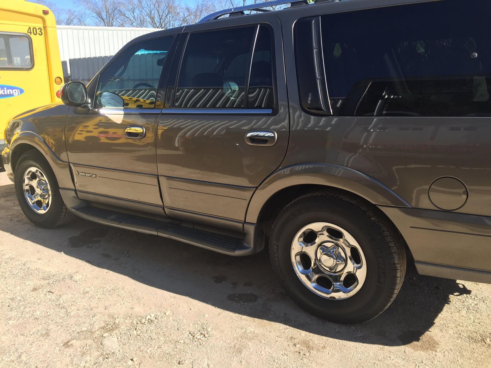 A ford expedition is parked next to a yellow bus