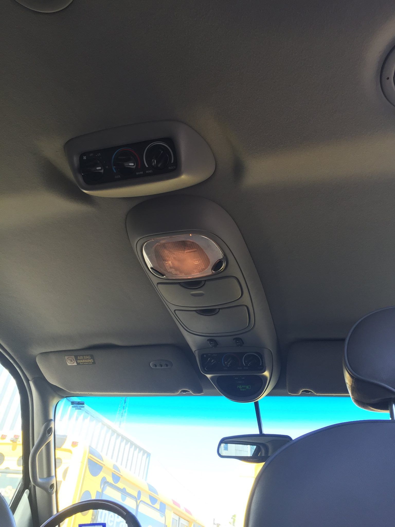 The ceiling of a car has a light on it