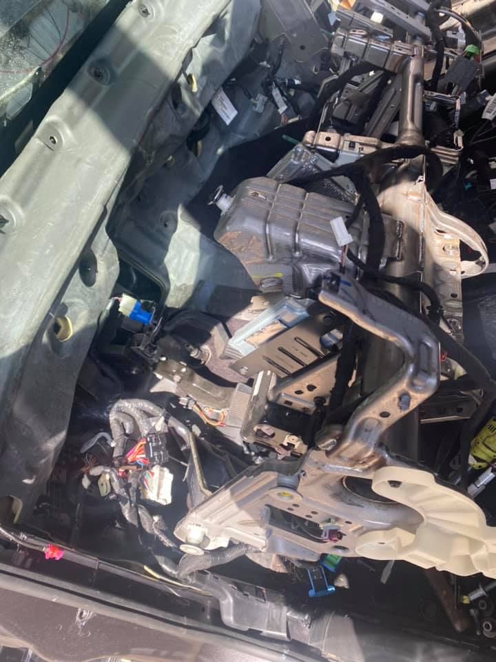 A close up of a car engine with the hood open.