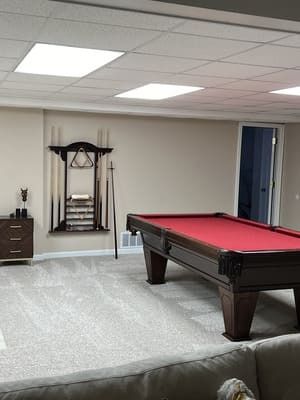 There is a pool table in the middle of the room.