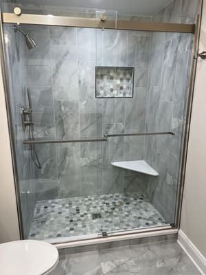 A bathroom with a sliding glass shower door and a toilet.