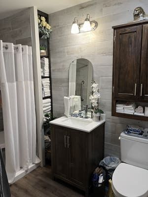 A bathroom with a sink, toilet, shower curtain, and mirror.