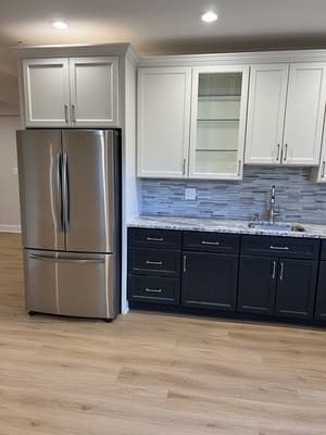 A kitchen with stainless steel appliances and black cabinets.