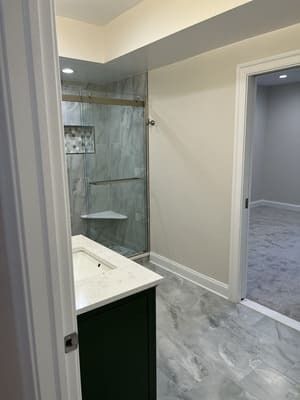 A bathroom with a sink and a walk in shower.