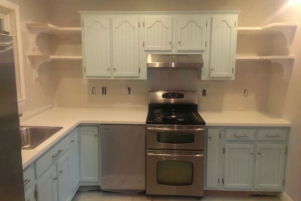 A kitchen with white cabinets and stainless steel appliances