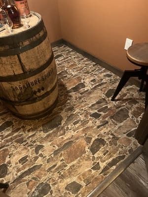 A wooden barrel is sitting on top of a stone floor in a room.