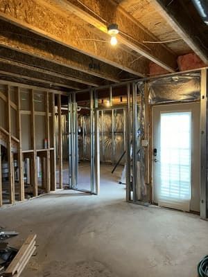 A basement under construction with a door and stairs.