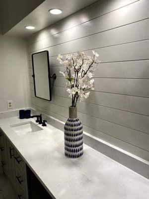 A vase of flowers is sitting on a bathroom counter next to a sink.