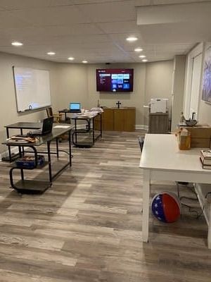 A large room with tables and a television on the wall.