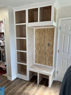 A room with a shelf and a bench in it.