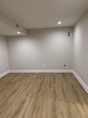 An empty room with hardwood floors and white walls.