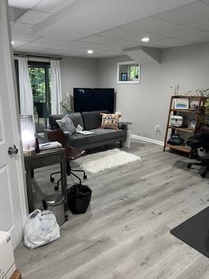 A living room with a couch , desk , chair and television.