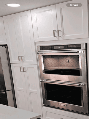 A kitchen with white cabinets and a stainless steel oven.