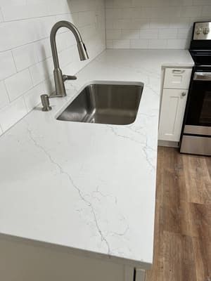 A kitchen with a stainless steel sink and a faucet.
