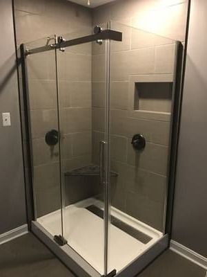 A shower stall with sliding glass doors in a bathroom.