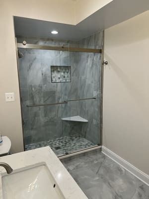A bathroom with a sliding glass shower door and a sink.