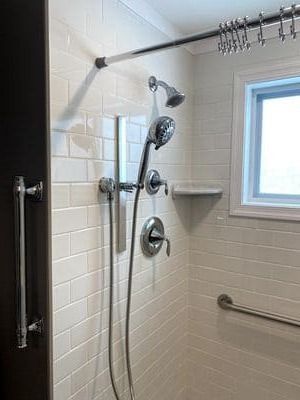 A shower with a shower head and a window.