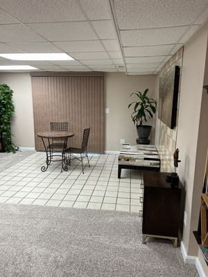 There is a table and chairs in the middle of the room.