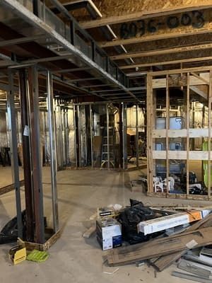 A basement under construction with a lot of wood and metal.