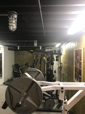 A gym with a lot of equipment and a picture on the wall.