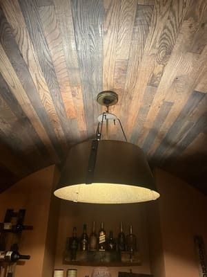 A pendant light is hanging from the ceiling of a room with wood paneling.