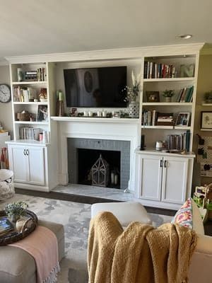 A living room with a fireplace and a flat screen tv.