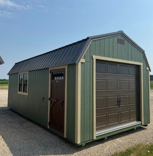 A barn with a ramp leading to it is sitting on top of a lush green field.