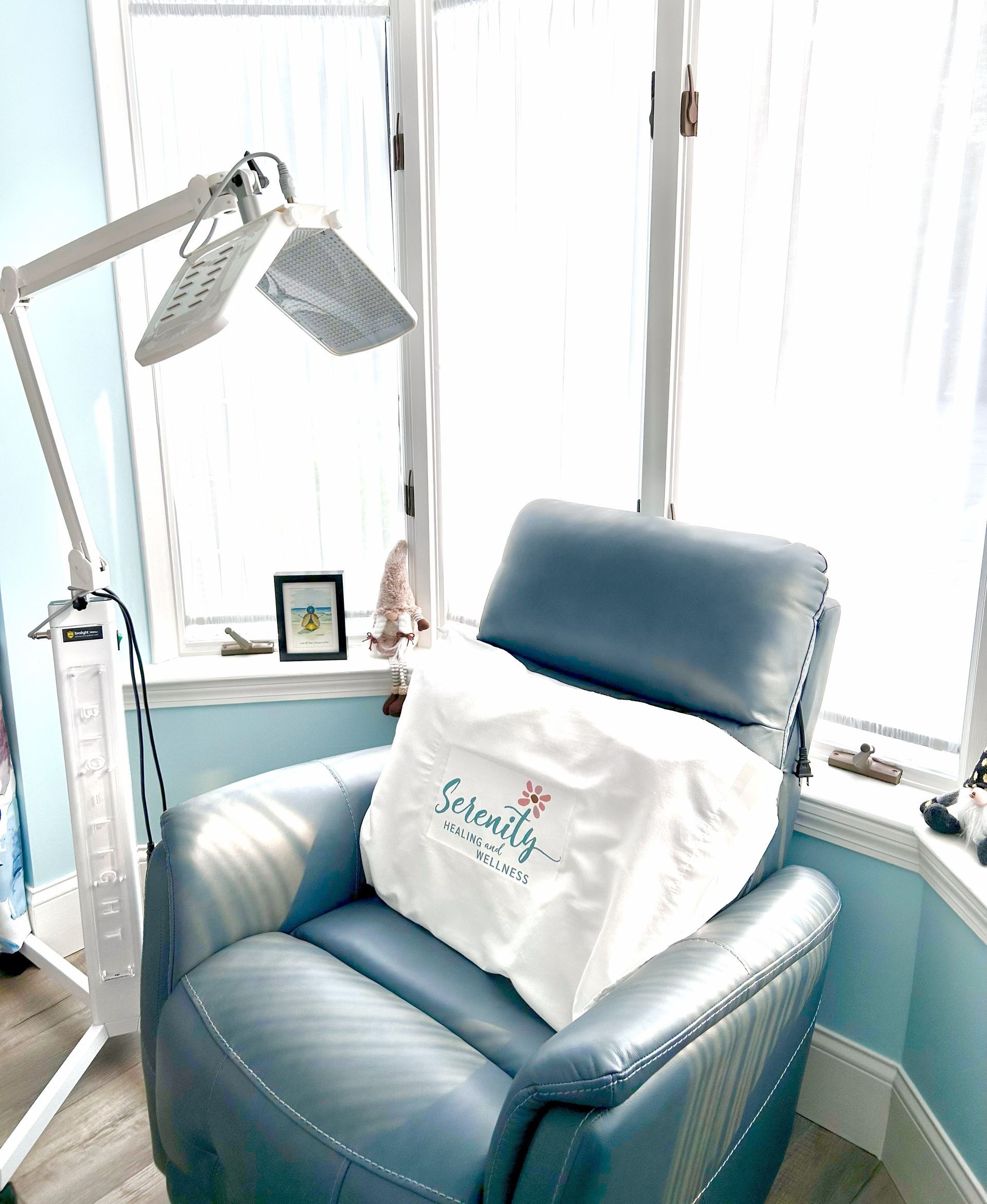 A blue recliner with a white pillow that says 