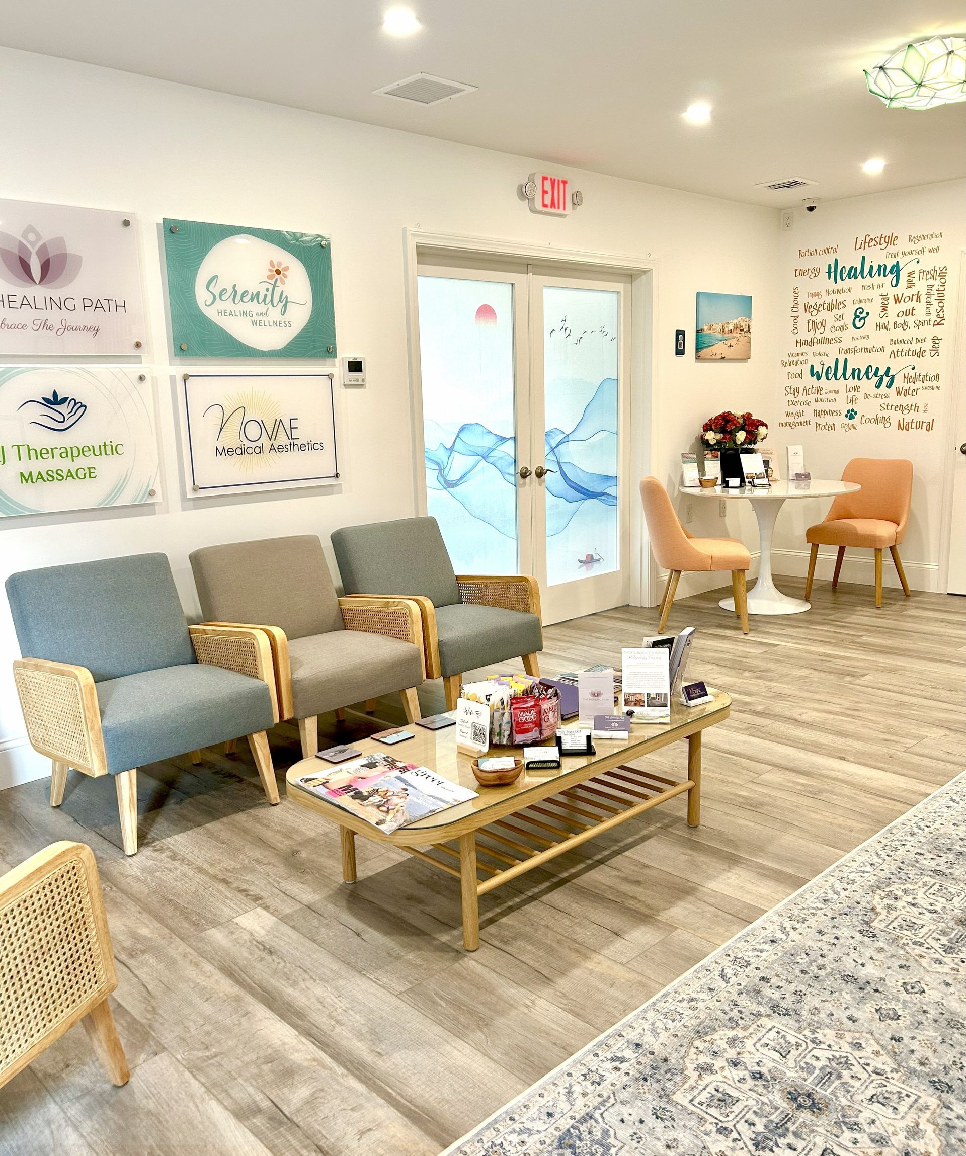 Waiting room with armchairs, coffee table, and wall art. Bright and airy with neutral tones.