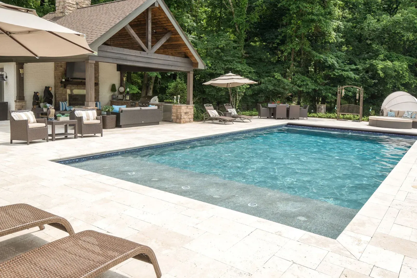 Poolside patio with pool, lounge chairs, and shaded seating area.