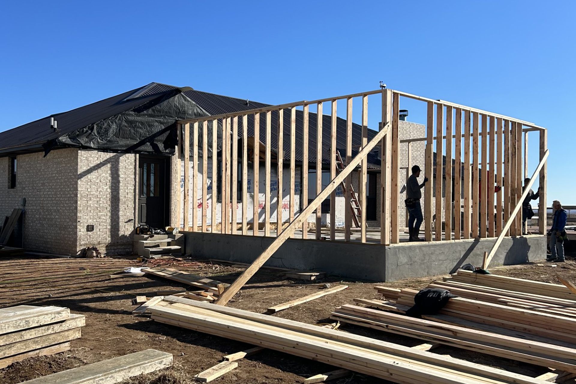 A house is being built with a lot of wood in front of it