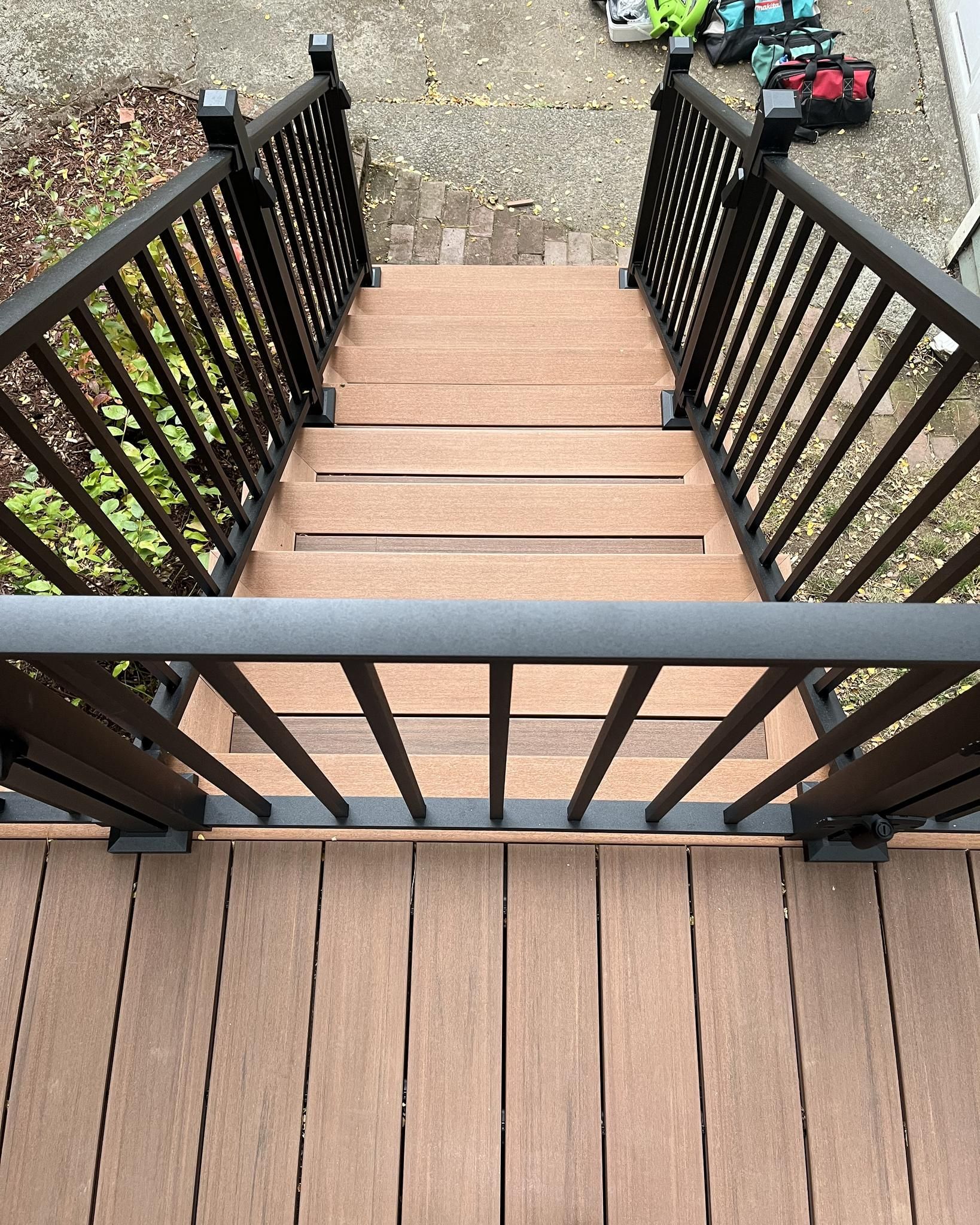 A wooden deck with black railing
