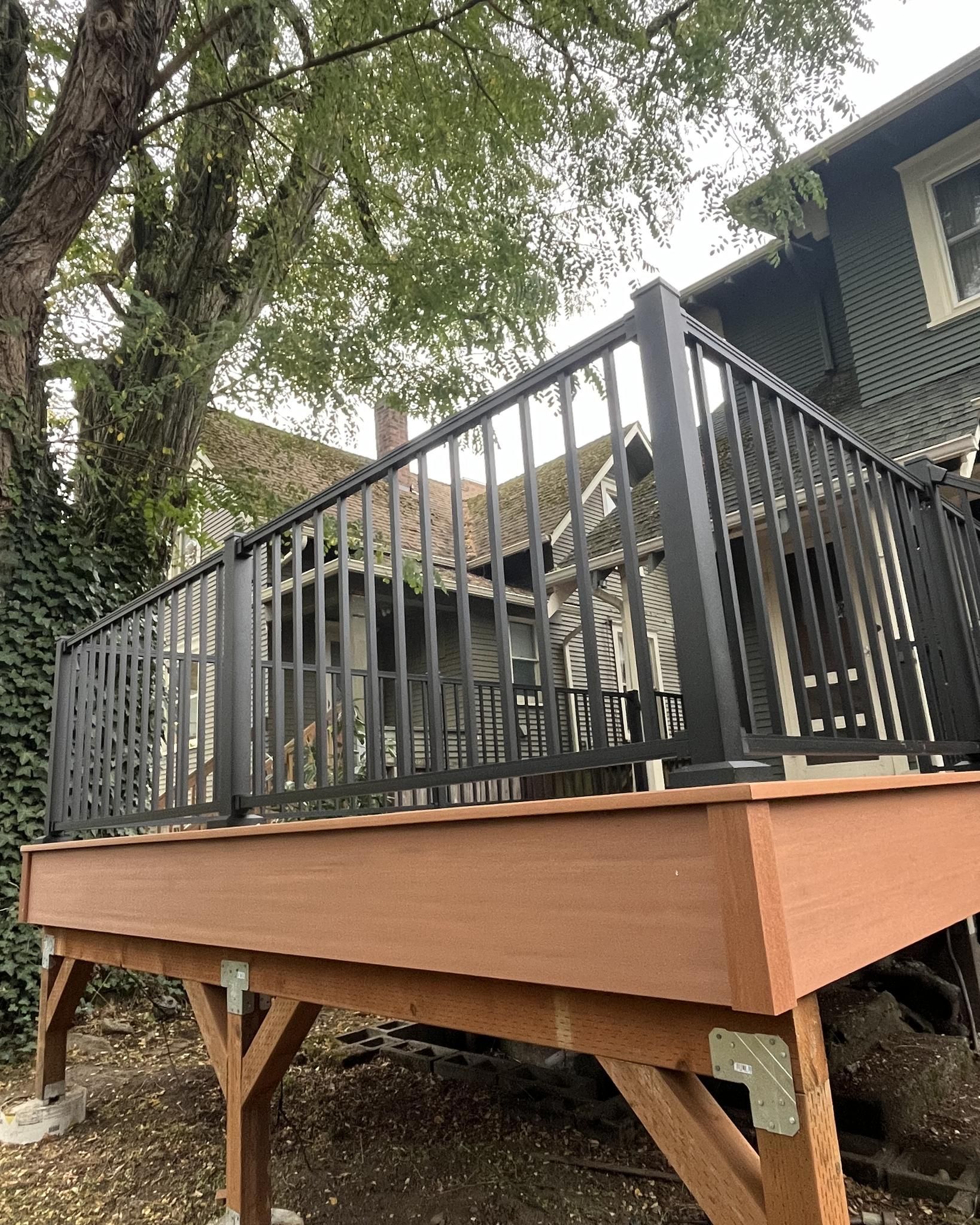 A wooden deck with black railing