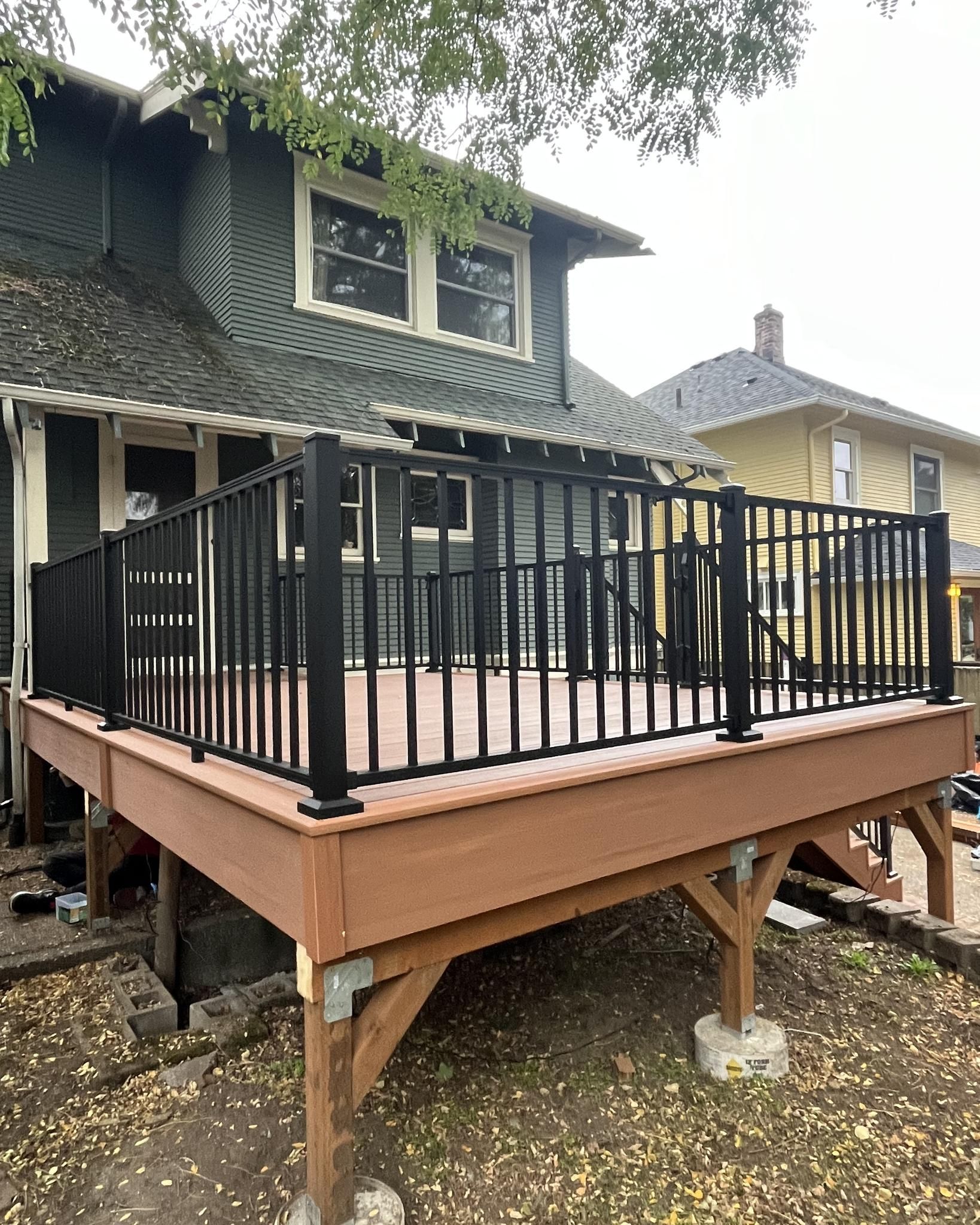 A wooden deck with black railing