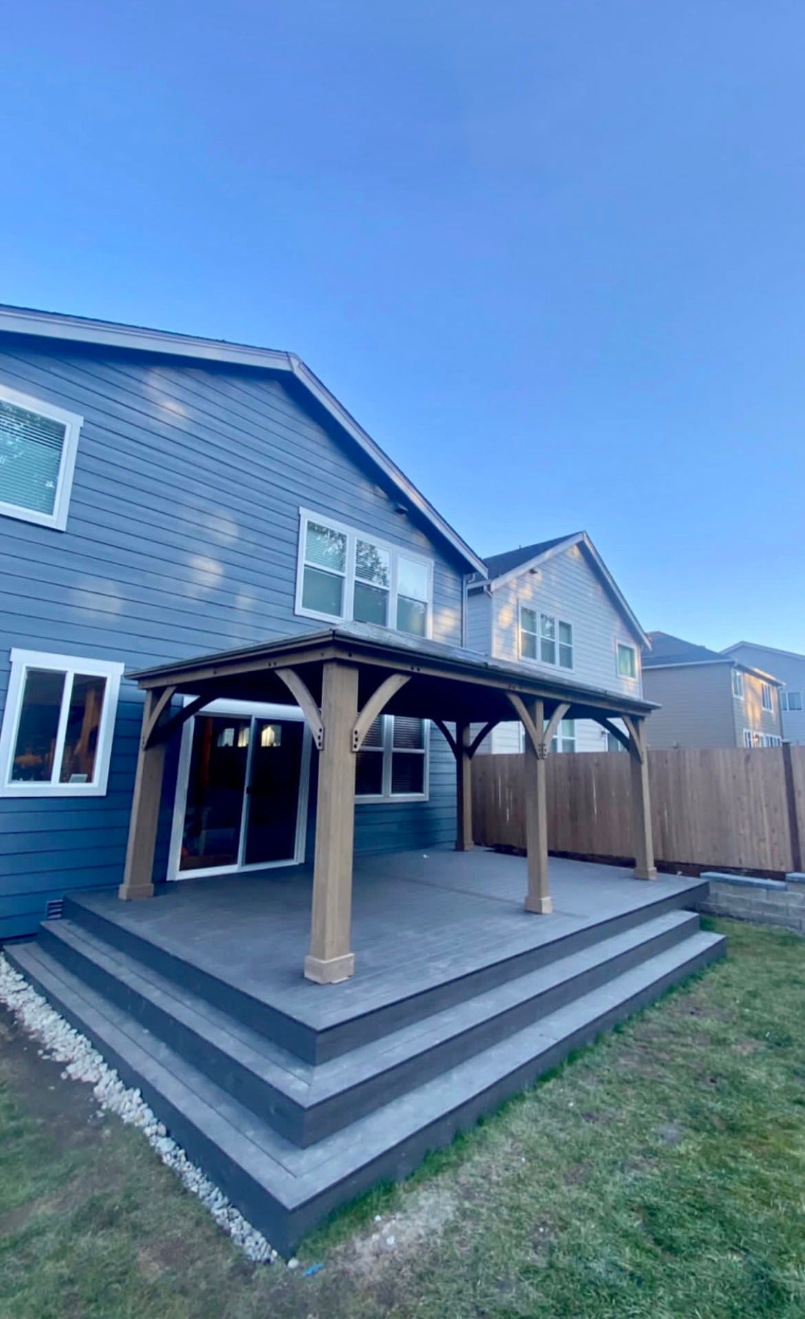 The back of a house with a covered patio and stairs.