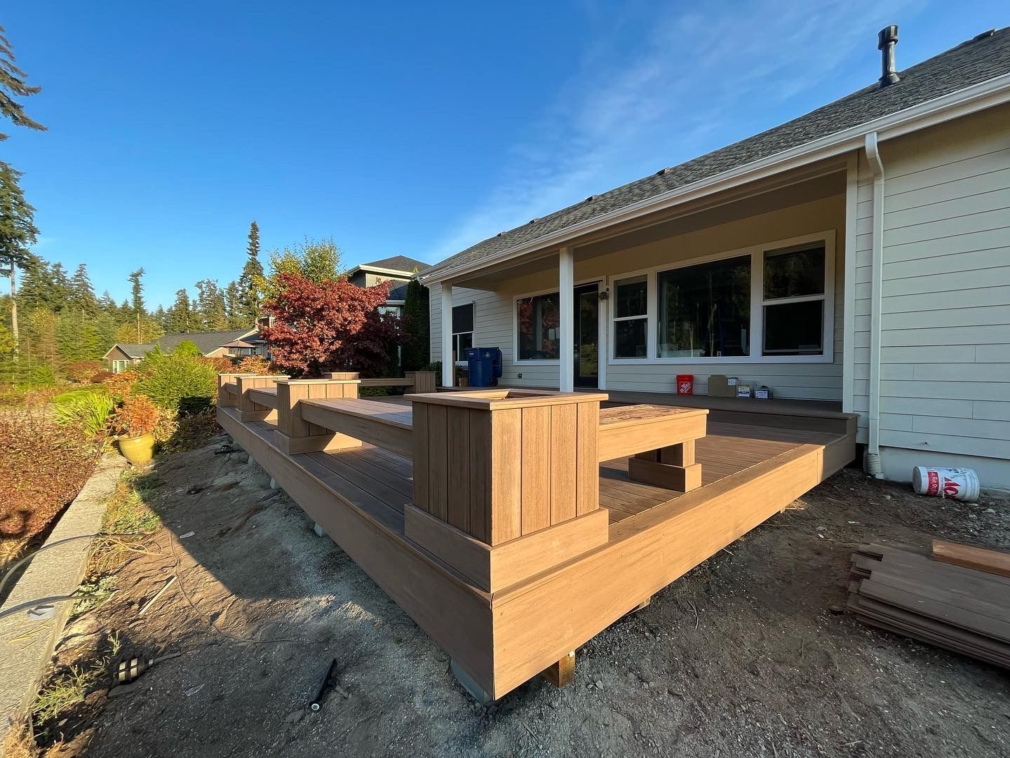 A wooden deck is being built in front of a house.