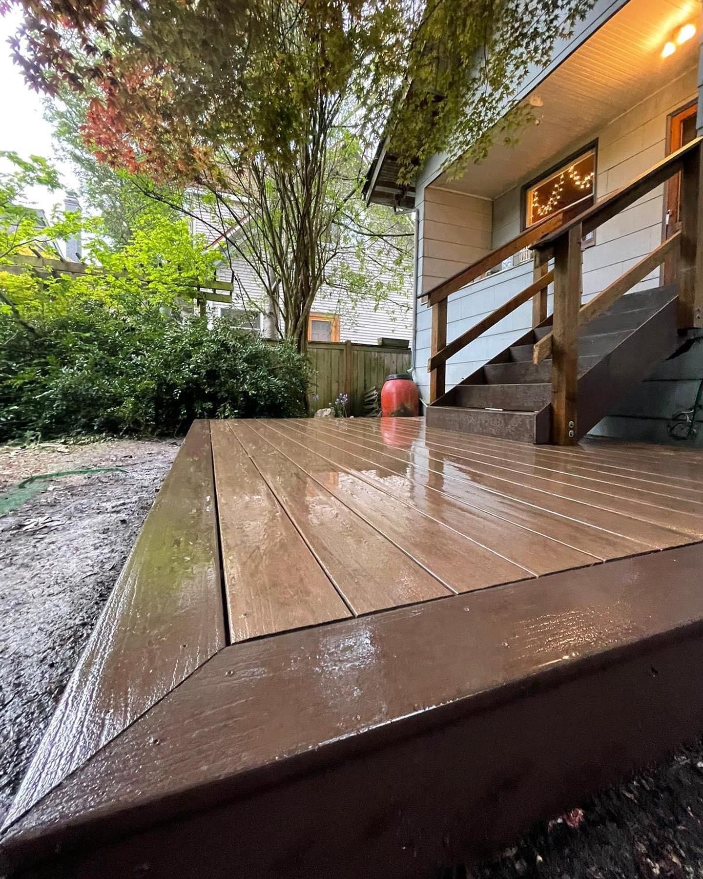A wooden deck with stairs leading up to a house.